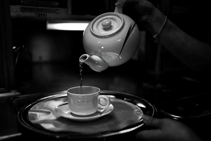 Black and white image of pouring tea into a cup