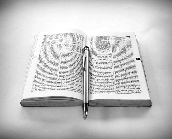 Open book with pen on white background