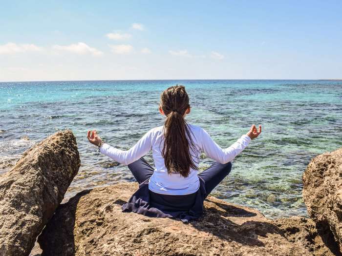 Girl meditating by the sea 4K