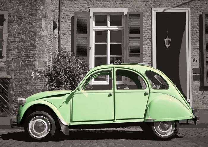 Green Citroen 2CV car in front of a brick building