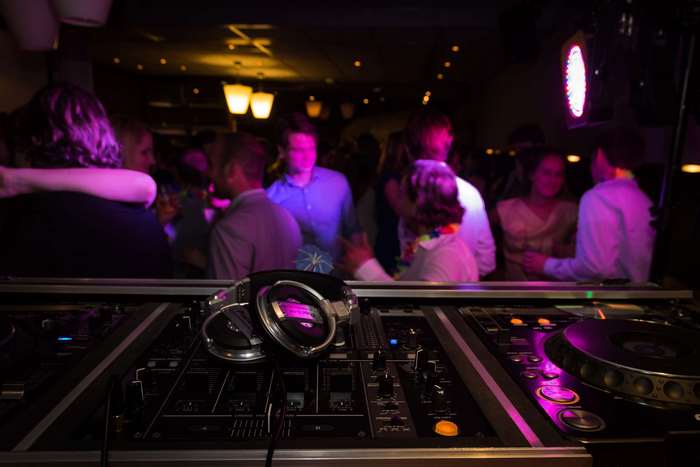 DJ equipment and partygoers in a nightclub