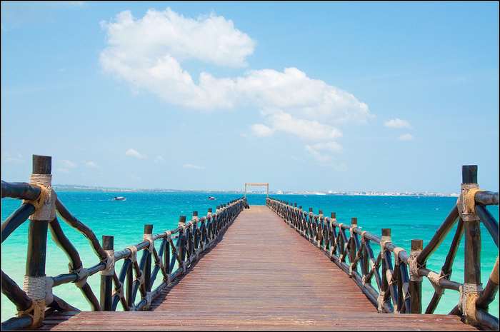 Wooden pier extending into the turquoise ocean under a blue sky