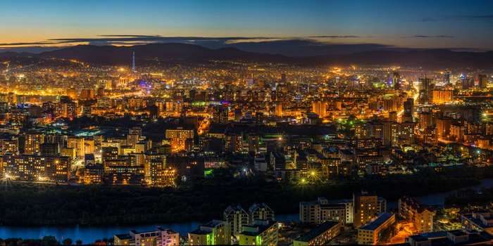 Cityscape at Dusk with Mountains and River