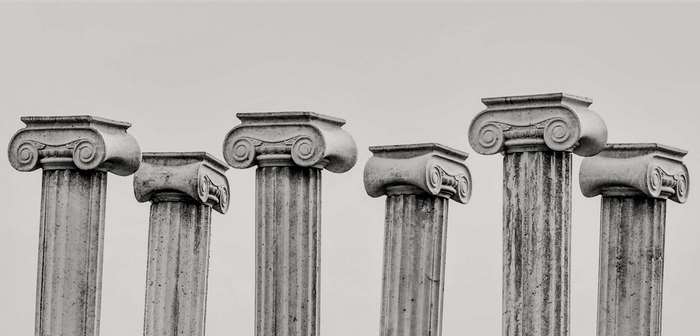 Ionic columns with volute capitals against a pale sky