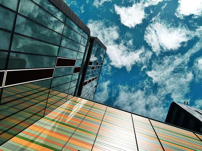 Modern glass buildings against a cloudy blue sky
