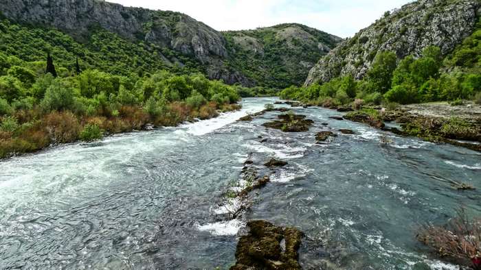 River flowing through a rocky canyon with green hills