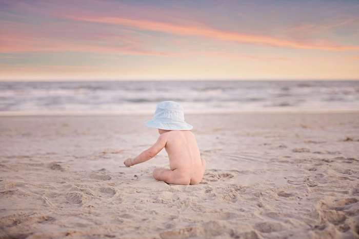 Baby on beach at sunset 4K