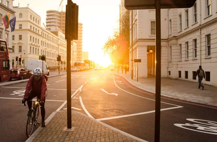 Cyclist on a street at sunrise in a city