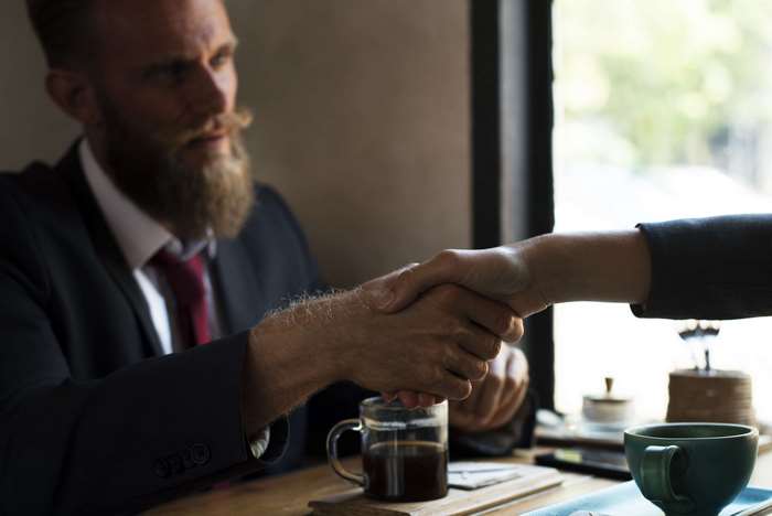 Man in Suit Shaking Hands Over Coffee 4K