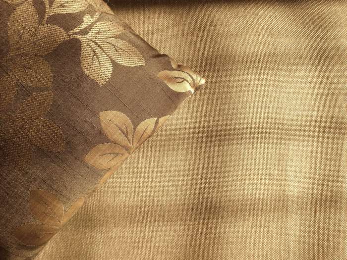 Brown fabric cushion with floral design and textured background