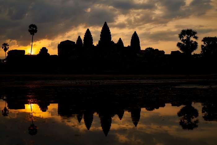 Angkor Wat temple silhouette at sunset with reflection