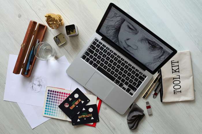 Artist's desk with laptop, drawing tools, and color swatches