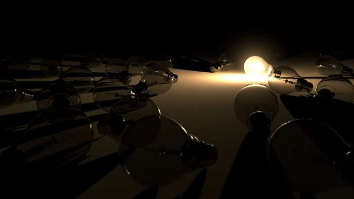 One lit light bulb among many unlit