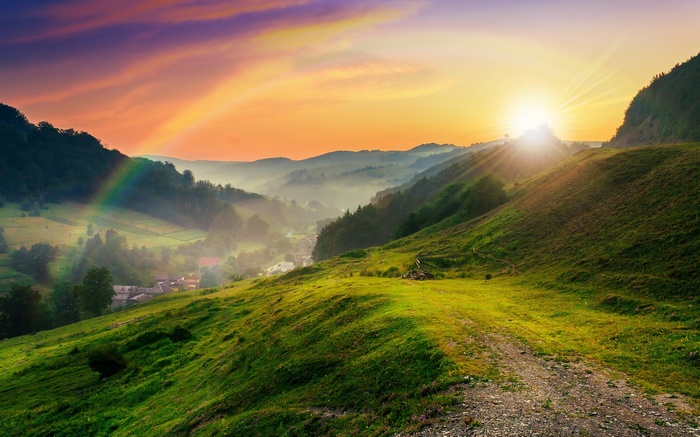 Sunrise over misty mountains with a rainbow