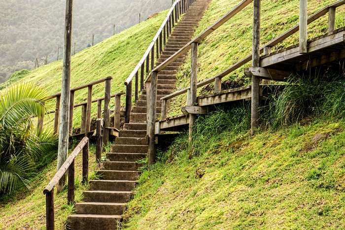 Stone stairs and wooden walkway on a grassy hill