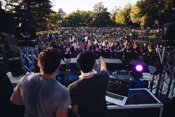 DJs performing for a large crowd at an outdoor concert