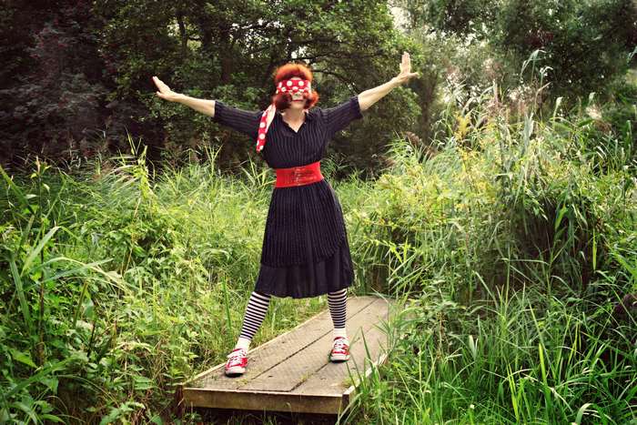 Woman with blindfold and striped socks posing in nature