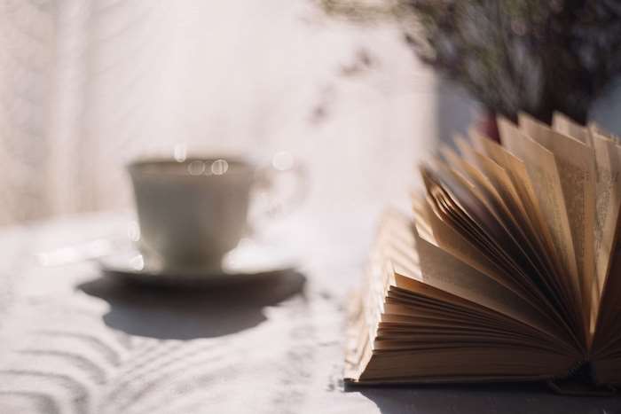 Open book and cup of coffee on a table