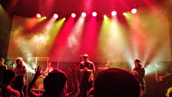 Live band performing on stage with colored smoke and lights