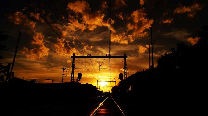 Train tracks at sunset with dramatic clouds