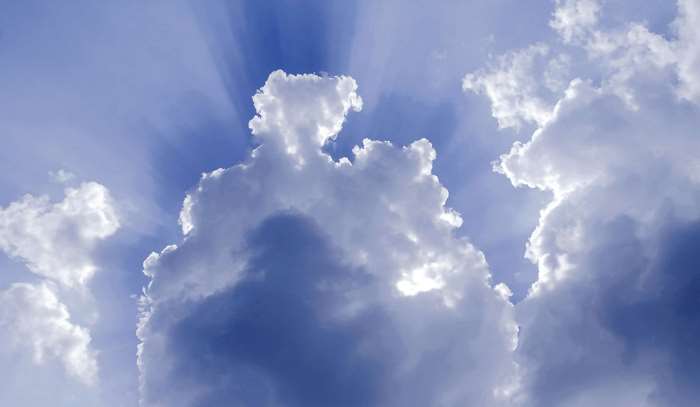 Sunbeams through clouds in blue sky 4K