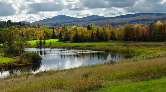 Autumn foliage around a lake with mountains in Vermont