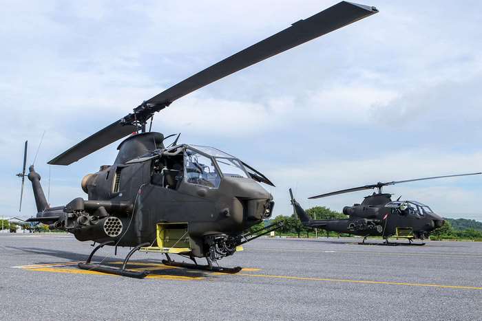 Two military helicopters parked on an airfield