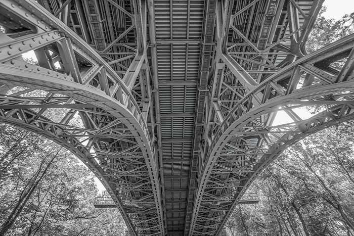 Underside of a steel bridge in black and white