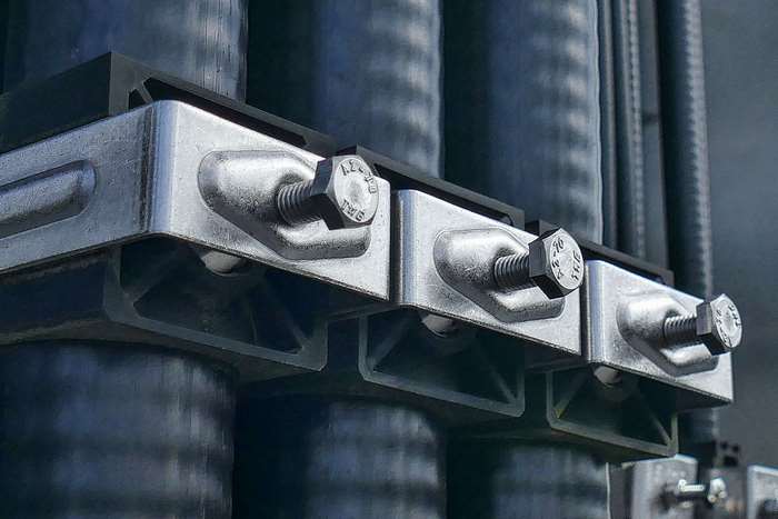 Industrial metal clamps holding pipes with bolts
