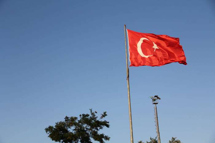 Turkish flag waving in the wind against a clear blue sky