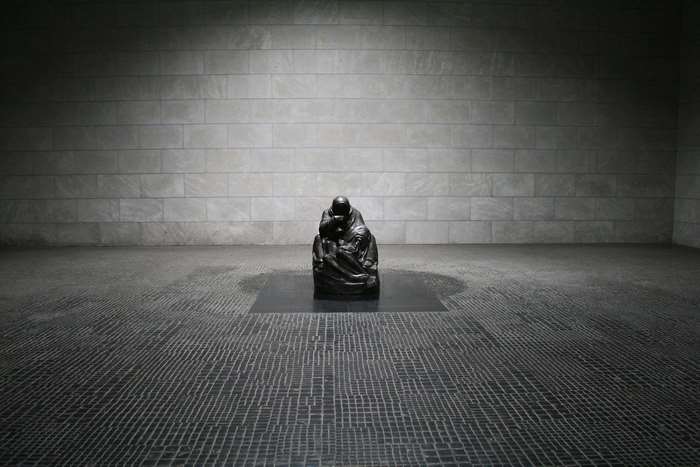 Sculpture of a seated figure in a museum hall