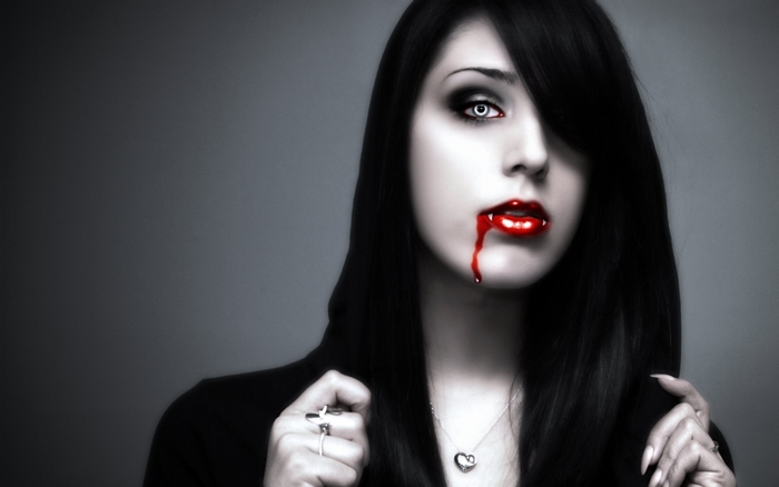 Gothic vampire woman with blood dripping from lips