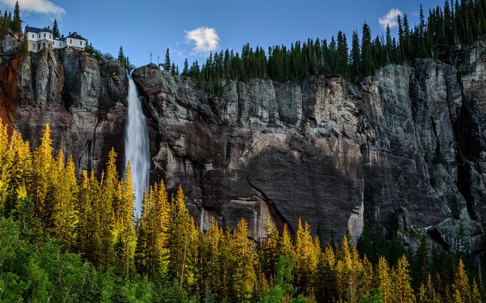 Waterfall cascading over a cliff with a building on top