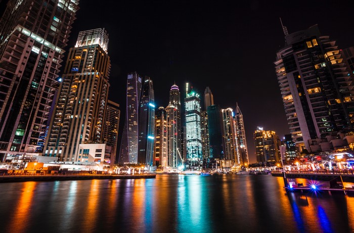 Dubai skyscrapers at night with water reflections