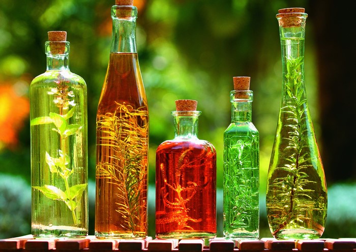 Colorful oil bottles with herbs inside