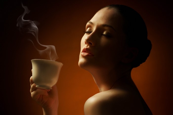 Woman Enjoying Warm Coffee with Closed Eyes