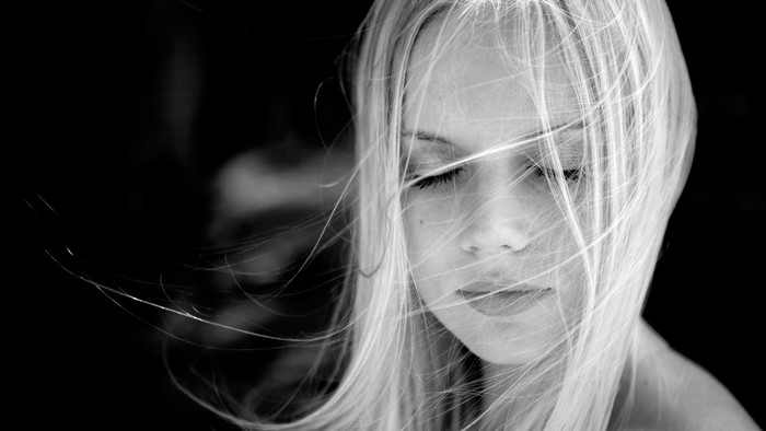 Black and white portrait of a blonde girl with eyes closed