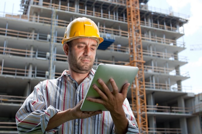 Construction worker with tablet at building site
