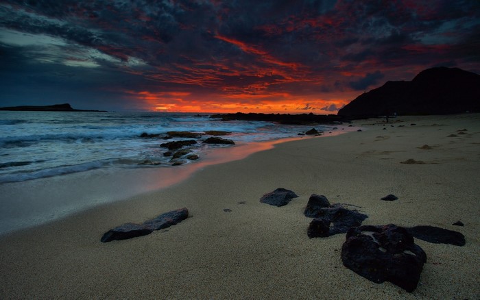 Beach at sunset with dramatic sky and ocean waves