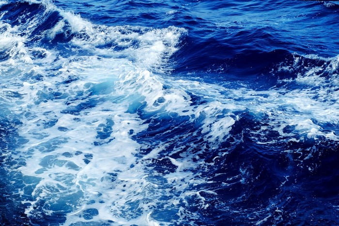 Deep blue ocean waves with white foam