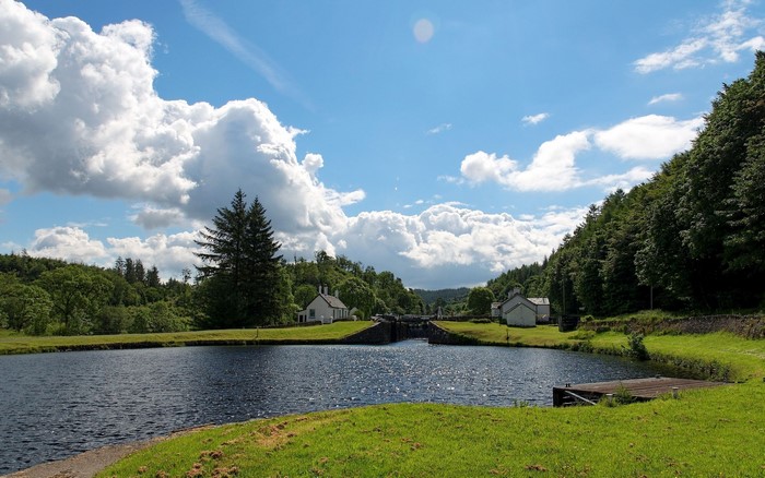 Peaceful River Landscape with Green Grass and Blue Sky