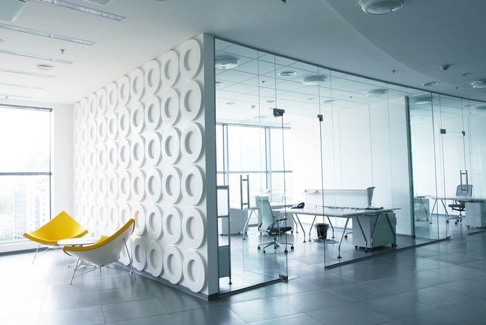 Modern office interior with glass walls and decorative wall