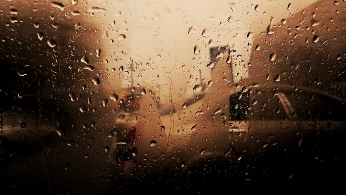 Raindrops on a window with blurred city background