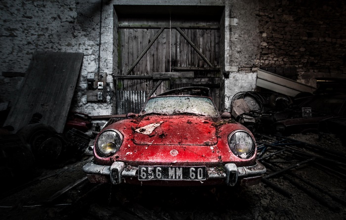 Abandoned red Fiat car in a barn