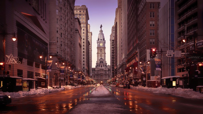 Snowy city street with historic clock tower in 4K