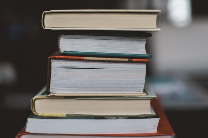 A stack of hardcover books on a dark background