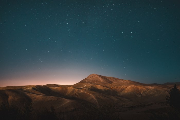 Desert mountains under a starry night sky