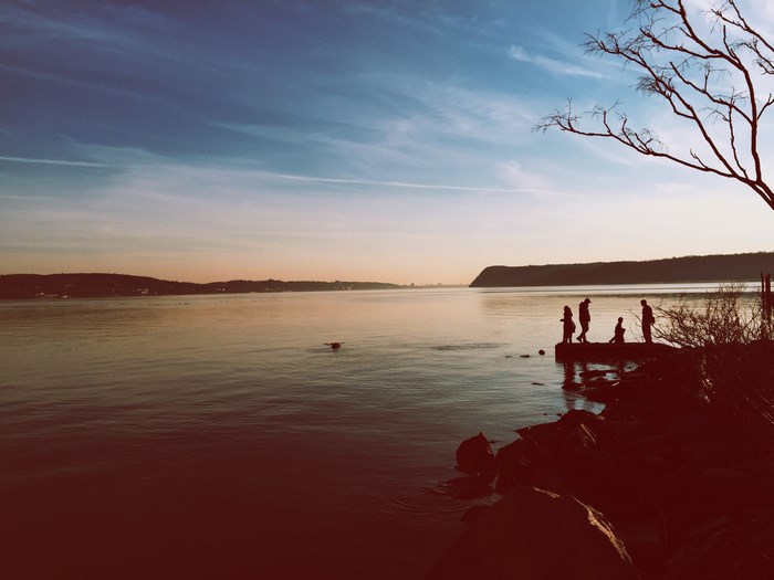 People fishing on a lake at sunset