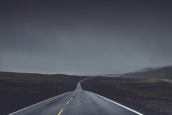 Empty highway stretching into a foggy landscape