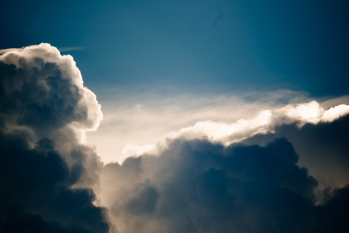 Dark storm clouds against a blue sky